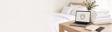 Laptop displaying a security lock beside white bed sheets and bath towels for the Linen King Australia Privacy Policy.
