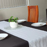 White satin striped table runner displayed on a dining table, made from a durable cotton blend to create an elegant table setting for Australian homes, restaurants, hotels and special occasions.